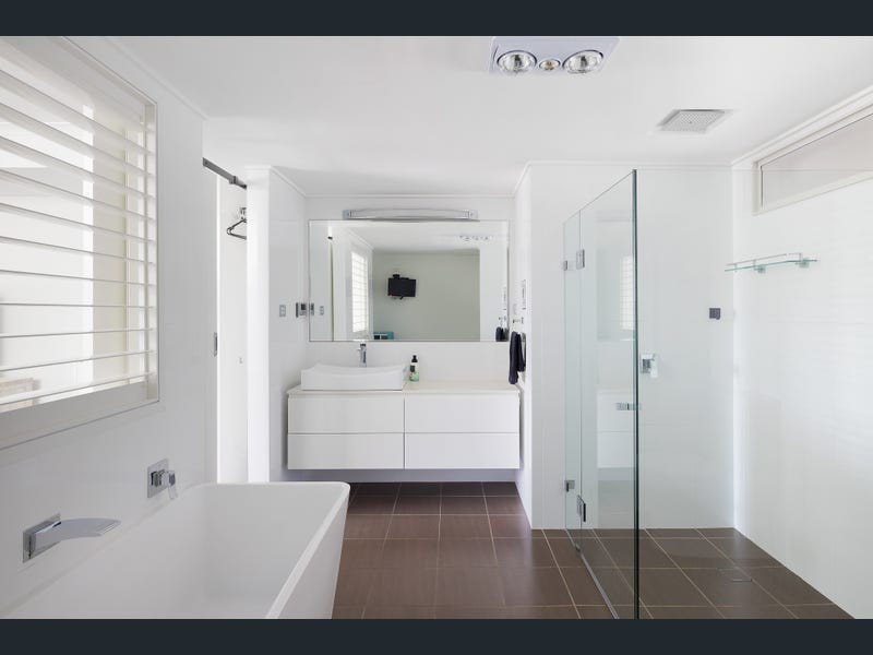 Bay room ensuite with bathtub, shower, large mirror and sink